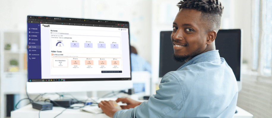 Young man sits at a desk with TOEFL results on his computer screen