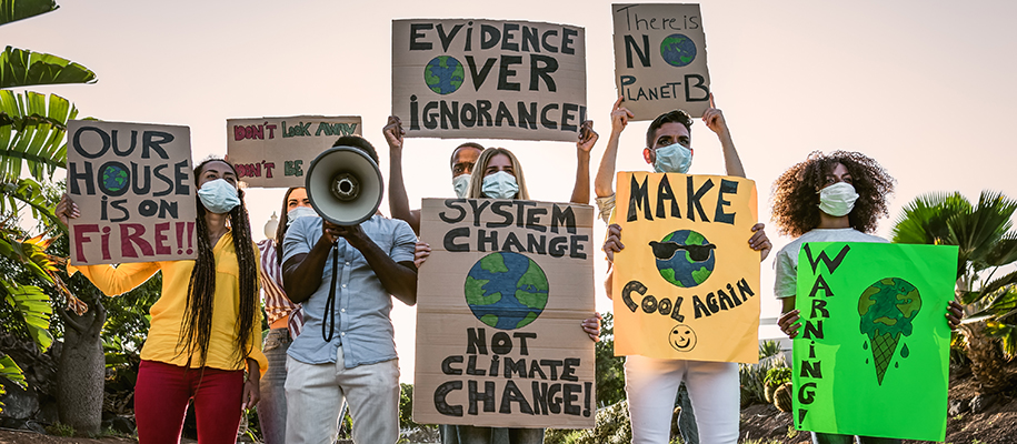 Group of diverse students in face masks with climate change protest signs