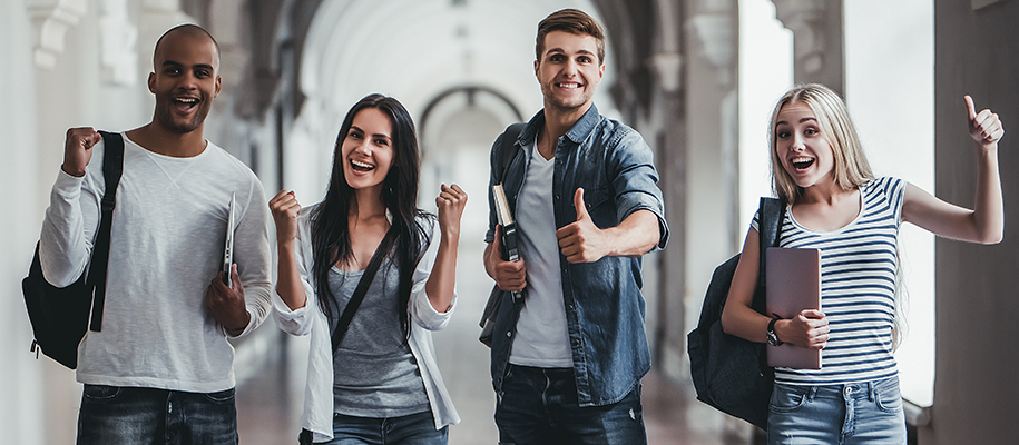 Two women and two men giving thumbs up, excited faces with bags, books