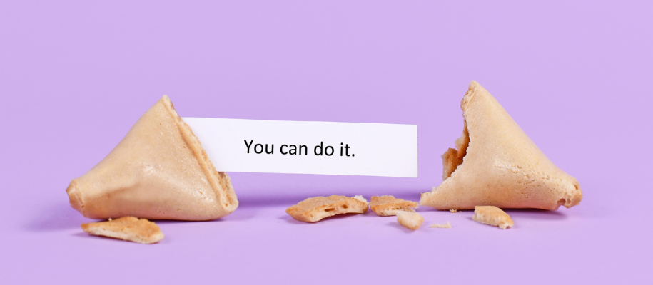 Broken fortune cookie with fortune "you can do it" on lilac colored backdrop