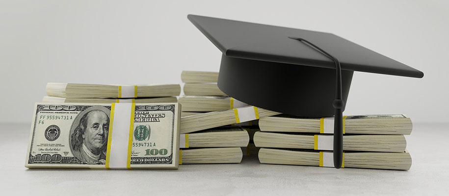 Black graduation cap sitting on piles one hundred dollar bill stacks