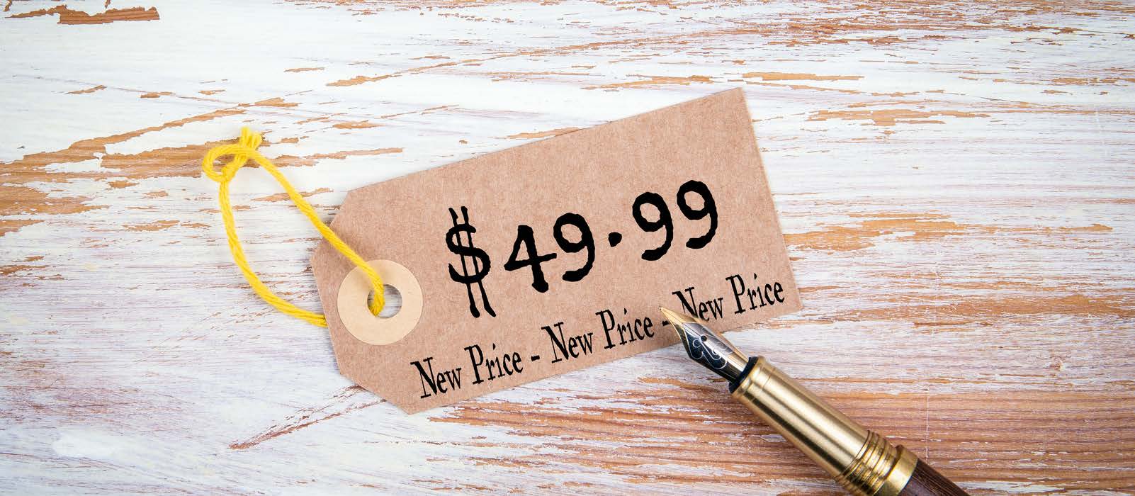Price tag reading $49.99 and New Price three times, yellow string, fountain pen