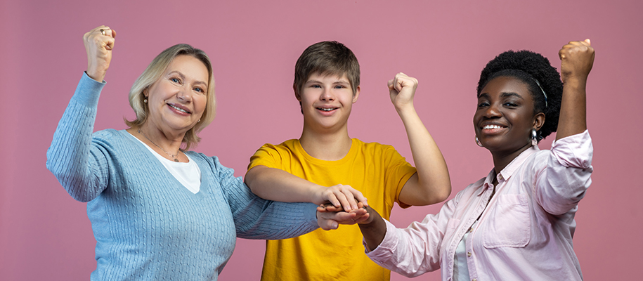 Two women counselors, young male w/ down syndrome, hands together, fists raised
