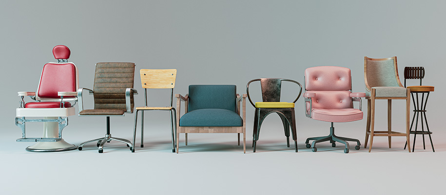 Line of various chairs of wood, metal, and upholstery on gray studio backdrop