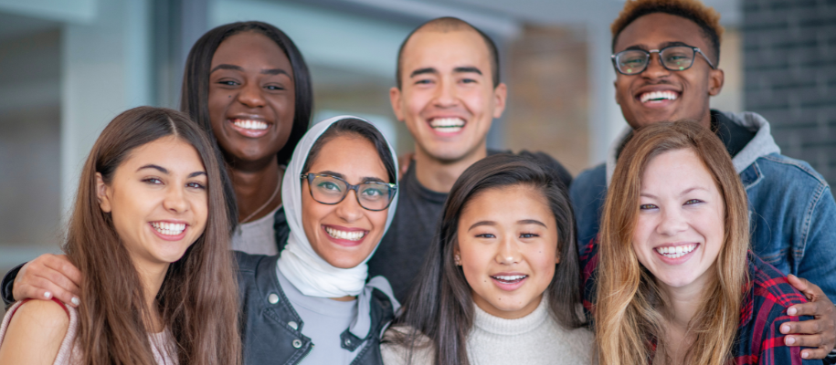 Diverse group of college students (four women and three men) smiling together